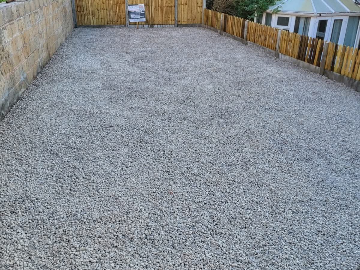 Gravel driveway laid between new timber fence panels
