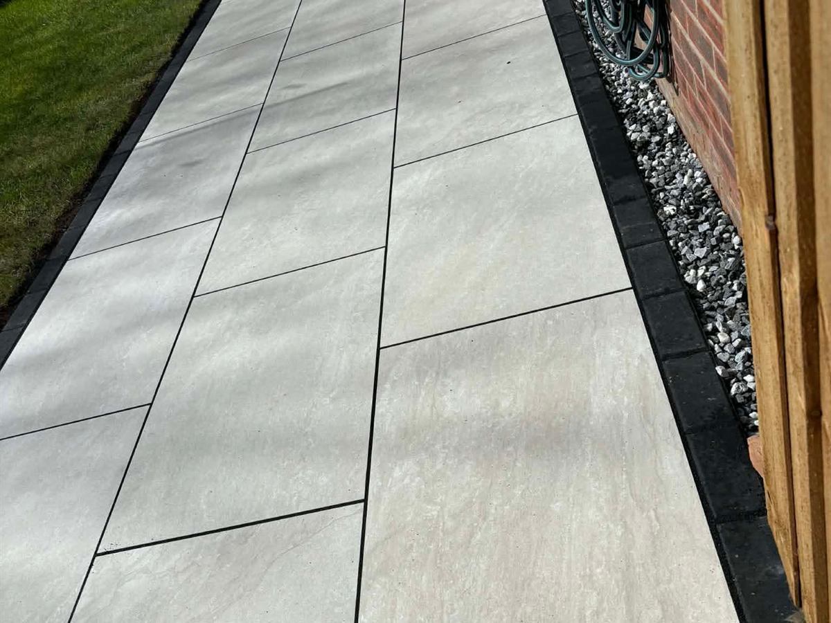 Porcelain paved path running down the side of a house